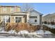 Tan two-story townhouse with a wooden fence and snow on the ground at 11565 Decatur St # 7D, Denver, CO 80234