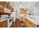 Kitchen with wood cabinets, white appliances and hardwood floor at 11565 Decatur St # 7D, Denver, CO 80234