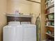 Bright laundry room with washer, dryer, and ample shelving at 11565 Decatur St # 7D, Denver, CO 80234