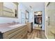 Bathroom featuring dual sinks, walk-in closet, and glass shower at 1673 Woodmoor Dr, Monument, CO 80132