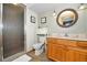 Bathroom featuring a glass shower enclosure, vanity with countertop, and a round mirror at 1673 Woodmoor Dr, Monument, CO 80132