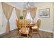 Charming dining area features a wooden table, decorative curtains, and stylish light fixture at 1673 Woodmoor Dr, Monument, CO 80132