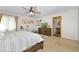Bright main bedroom features a ceiling fan, a dresser with TV, and a door to the main bath at 1673 Woodmoor Dr, Monument, CO 80132