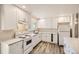 Clean kitchen with white cabinets, countertops, and appliances, plus modern flooring and recessed lighting at 3205 Moorhead Ave, Boulder, CO 80305