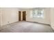 Bright, carpeted living room with natural light from a large window and two doors, freshly painted and move-in ready at 3205 Moorhead Ave, Boulder, CO 80305