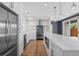 Modern kitchen with stainless steel appliances, sleek white cabinetry, and a spacious island with pendant lights at 3770 Osceola St, Denver, CO 80212