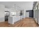 Modern kitchen with white cabinetry, stainless steel appliances, hardwood floors, and sleek island with pendant lighting at 3770 Osceola St, Denver, CO 80212