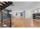 Open-concept living area featuring modern staircase, hardwood floors, fireplace, and seamless flow into the kitchen at 3770 Osceola St, Denver, CO 80212