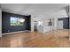 Open-concept living space with modern chandelier and hardwood floors leads into kitchen with stainless appliances at 3770 Osceola St, Denver, CO 80212