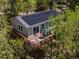 Aerial view of home with solar panels and a deck surrounded by lush green trees at 11650 Baca Rd, Conifer, CO 80433