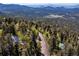 An aerial view showing the property's location nestled among trees and a scenic roadway at 11650 Baca Rd, Conifer, CO 80433