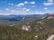 Expansive aerial view of lush green mountains and the natural beauty that surrounds this home at 11650 Baca Rd, Conifer, CO 80433