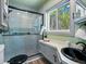 Modern bathroom with glass shower, black hardware, and a large window at 11650 Baca Rd, Conifer, CO 80433