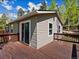 Exterior view featuring a wood deck, sliding glass door, vinyl siding, and lush trees at 11650 Baca Rd, Conifer, CO 80433