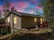 Exterior of home with dual decks at sunset surrounded by lush trees and a dark roof at 11650 Baca Rd, Conifer, CO 80433