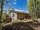Exterior of home with dual decks surrounded by trees, a dark roof, and beautiful landscaping at 11650 Baca Rd, Conifer, CO 80433