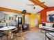 Open-concept living area with a wood-burning stove, a dining area, and access to the kitchen at 11650 Baca Rd, Conifer, CO 80433