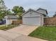 Two-story gray home featuring an attached two-car garage, driveway and well-maintained lawn at 745 Stowe St, Highlands Ranch, CO 80126