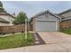 Charming home features a two-car garage, a well-manicured lawn, and a welcoming entrance at 745 Stowe St, Highlands Ranch, CO 80126