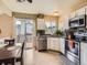 Modern kitchen with white cabinets, stainless steel appliances, and access to the back deck at 745 Stowe St, Highlands Ranch, CO 80126