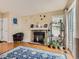 A cozy living room featuring a fireplace, plants, and a large window providing natural light at 745 Stowe St, Highlands Ranch, CO 80126
