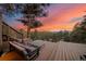 Beautiful back deck with comfortable seating and stunning views of the surrounding forest during a colorful sunset at 24798 Foothills N Dr, Golden, CO 80401