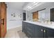 Elegant bathroom with a double vanity, marble countertops, gold hardware, and a decorative sliding barn door at 24798 Foothills N Dr, Golden, CO 80401