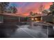 Exterior view of a home with a three-car garage, tile roof, and well-maintained driveway at 24798 Foothills N Dr, Golden, CO 80401
