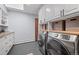 Bright laundry room featuring modern washer and dryer units, and ample cabinet space at 24798 Foothills N Dr, Golden, CO 80401