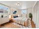 Sunlit bedroom with hardwood floors, modern decor, and two windows for natural light at 10 Merideth Ln, Longmont, CO 80501