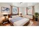 Well-lit bedroom featuring hardwood floors, a comfortable bed, and ample natural light at 10 Merideth Ln, Longmont, CO 80501