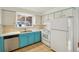 Classic kitchen features stainless steel dishwasher, white appliances and cheerful turquoise lower cabinets at 10 Merideth Ln, Longmont, CO 80501