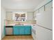 Functional kitchen featuring light blue cabinets, white appliances, and a bright window at 10 Merideth Ln, Longmont, CO 80501