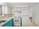 Efficient kitchen with white appliances, light blue accents, and tiled flooring at 10 Merideth Ln, Longmont, CO 80501