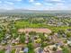 Wide aerial shot of a peaceful neighborhood with an open field and beautiful mountain backdrop at 5370 S Union Way, Littleton, CO 80127