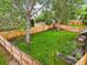 An expansive fenced backyard with mature trees, lush grass, and a small garden at 5370 S Union Way, Littleton, CO 80127