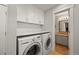 Well-lit laundry room featuring white cabinetry, quartz countertops, and modern washer and dryer at 5370 S Union Way, Littleton, CO 80127