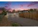 Home exterior with driveway and fenced yard under a beautiful sunset sky at 3015 Pierce St, Wheat Ridge, CO 80214