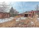 View of a brick house backyard with a small shed and snow-covered ground at 950 Jasmine St, Denver, CO 80220