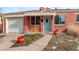 Charming brick home featuring a light blue front door, awning, garage, and attractive landscaping at 950 Jasmine St, Denver, CO 80220