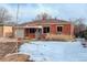A well-maintained brick home with snowy front yard and tidy landscaping, providing curb appeal at 950 Jasmine St, Denver, CO 80220