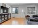 Bright living room with light hardwood floors, front door, and large windows offering natural light at 950 Jasmine St, Denver, CO 80220