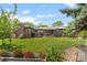 Spacious backyard with lush lawn, patio area, brick fireplace, and mature trees at 5455 E Iowa Ave, Denver, CO 80222