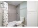 Stylish bathroom featuring gray tiled walls in shower, modern toilet and ample storage space at 5455 E Iowa Ave, Denver, CO 80222