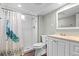 Bathroom featuring a tiled shower, vanity, and a decorative peacock curtain at 5455 E Iowa Ave, Denver, CO 80222