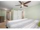Bedroom with a large ceiling fan, carpeted floors, and plenty of closet space at 5455 E Iowa Ave, Denver, CO 80222