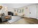 Inviting living room with piano, hardwood floors, and a large sunlit window at 5455 E Iowa Ave, Denver, CO 80222