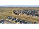 Aerial view of new community showing houses, streets, and green spaces with mountain views at 806 Flora View Dr, Erie, CO 80516