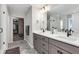 Modern bathroom featuring dual sinks, quartz countertops, and a walk-in shower with glass door at 806 Flora View Dr, Erie, CO 80516
