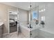 Bright bathroom featuring a soaking tub, glass-enclosed shower, and stylish white tile at 806 Flora View Dr, Erie, CO 80516
